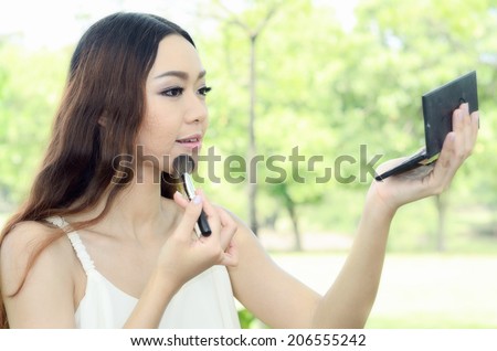 Asian women having applied foundation makeup at the park / Portrait Asia women
