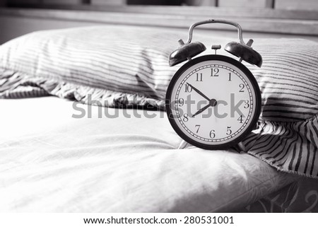 Black and White Alarm clock on bed at home / Alarm clock