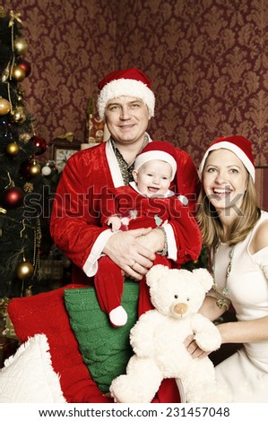 Happy family on Christmas and New Year. Father Mother and baby in Christmas designed home.  Santa Close, Baby dwarf and white princess