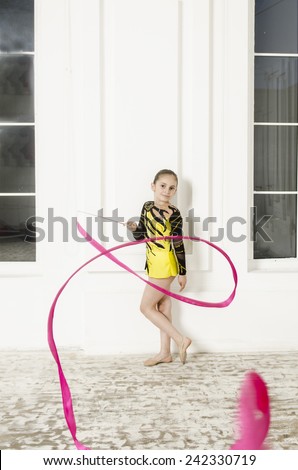 Sport training beautiful girl with Pink Rhythmic gymnastics ribbon in white room jumping and doing professional exercises