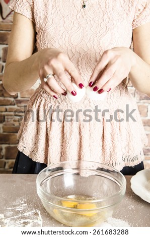 Beautiful picture of woman that beating eggs to a bowl. Taking eggs in hands