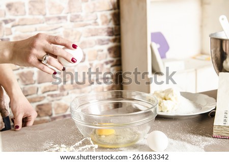Beautiful picture of woman that beating eggs to a bowl. Taking eggs in hands
