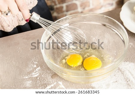 Beautiful picture of eggs in a white bowl with beaters near yolk