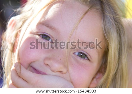 Six year old girl smiling with sunshine in her hair at the park
