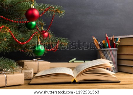 Teacher's table with books, organizer and chalkboard. The concept of Christmas and New Year.