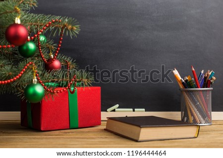Gift teacher\'s table with books, organizer and chalkboard. The concept of Christmas and New Year.