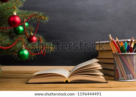 Teacher\'s table with books, organizer and chalkboard. The concept of Christmas and New Year.