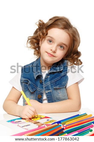 Cheerful little girl with felt-tip pen drawing in kindergarten.