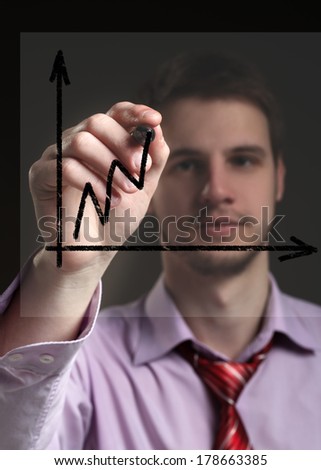 Businessman draws on a transparent screen graphics. Concept - presentation of success in business