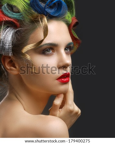 Fashion Portrait. Beautiful woman with colored hair, touching his face.