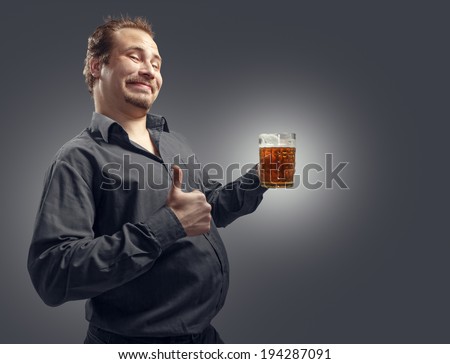 Satisfied man with beer on a dark background. Studio photography.
