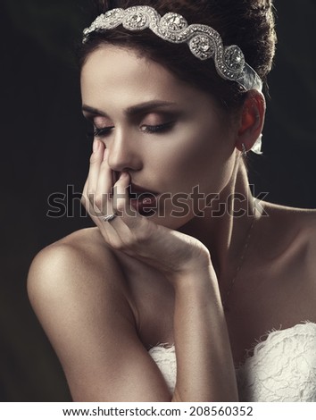 Beautiful woman in a white dress in the image of a bride with a sad face. Hand touching face. Instagramm style.