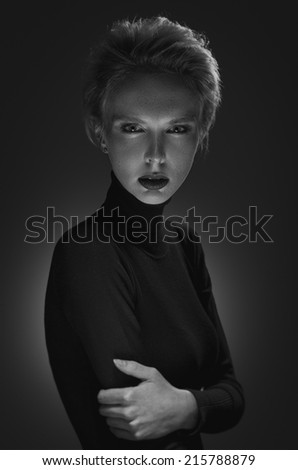 Black and white portrait of a mysterious blonde. Looking into the camera. Shallow depth of field.