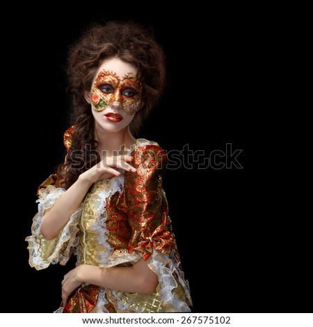 Faceart. Venetian mask. Beautiful woman in vintage dress and a mask on his face. Black background.