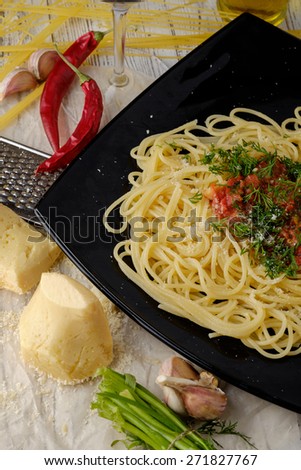 Italian pasta cooked in a rustic style with a sauce of fresh tomatoes and garlic on a wooden table. Top view