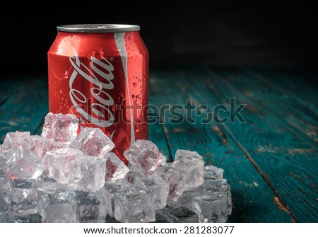 MINSK, BELARUS-MAY 22, 2015: Can of Coca-Cola in ice on wooden background. Coca-Cola is a carbonated soft drink sold in stores, restaurants, and vending machines throughout the world.