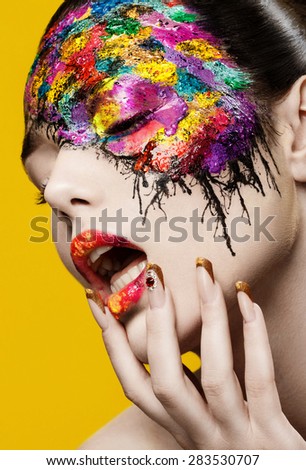 Beautiful fashion woman color face-art on yellow background