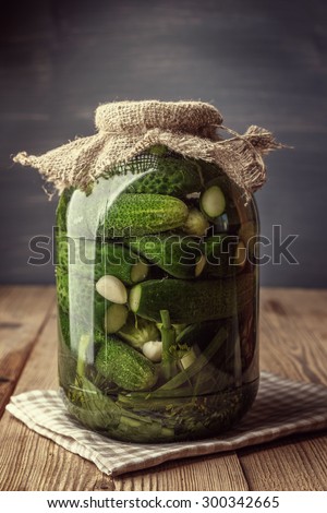 Jar of pickles on wooden table. Salted Cucumbers still-life. Toned.