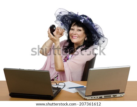 Mature woman applying compact powder on her face cause she is owner of on-line makeup courses