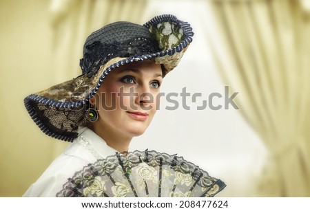Face portrait of beautiful adult woman wearing vintage hat with fan