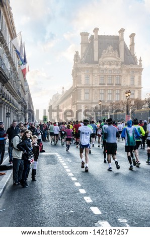 PARIS - APRIL 07: The participants of the 37th annual marathon run on the Rue de Rivoli near the Louvre. Spectators welcome them on April 07, 2013 in Paris, France