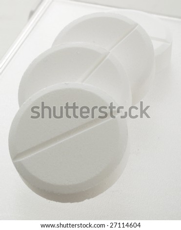 handful of white pills on a lid