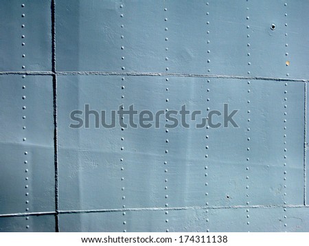 Detailed gray metal historic World War 2 ship wall with seams and rivets. with a chip of paint.