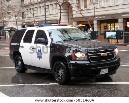 SAN FRANCISCO -  JANUARY 20: Ford Explorer SFPD cop vehicle rolls down market street during a Protest for \'House Keys, not handcuff\' on rainy day.   January 20, 2010 San Francisco California.