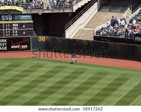 OAKLAND, CA - AUGUST 4: Royals vs. Athletics: Athletics Rajai Davis opens glove to catch ball in the outfield by the warning track fence.  Taken on August 4 2010 at Coliseum in Oakland California.