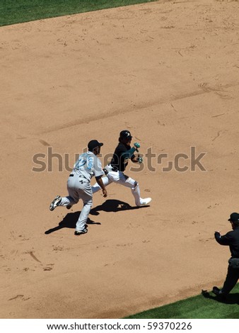 OAKLAND, CA - AUGUST 18: Blue Jays vs. Athletics: Athletics Coco Crisp is ran after by Blue Jays SS Yunel Escobar during a run down play.  Taken on August 18 2010 at Coliseum in Oakland California.