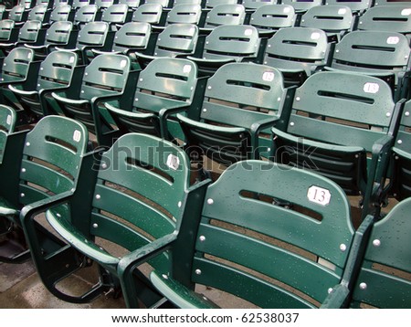 Rows of empty wet green stadium seats, seats number 13, 12, 11. AT&T Park San Francisco