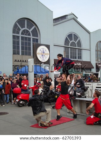 SAN FRANCISCO- JANUARY 16: English Circus performers put on a show as a man balances his sister on his shoulders, almost drops her on man from crowd January 16, 2010 at Ferry Building San Francisco.