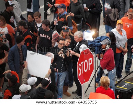 SAN FRANCISCO, CA - OCTOBER 28: TV Reporter does live report as fans gather around and one hold sign behind him game 2 of the 2010 World Series game Oct. 28, 2010 AT&T Park San Francisco, CA.