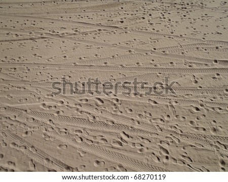 Beach Sand with foot prints and tire tracks on Santa Monica Beach. texture works well as abstract background. Sand pattern.