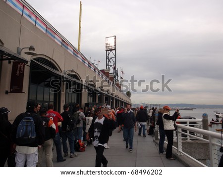 SAN FRANCISCO, CA - OCTOBER 27: Giants fans line up to get into free section as man hold sign walks by game 1 2010 World Series game Giants and Rangers Oct. 27, 2010 AT&T Park San Francisco,.