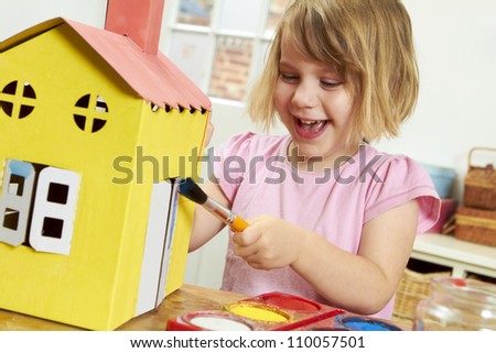 Young Girl Painting Model House Indoors