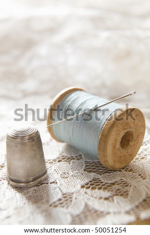 Vintage Cotton Reel With Needle And Silver Thimble On White Lace