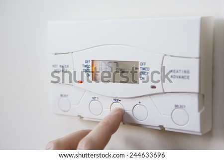 Close Up Of Hand  Setting Control For Heating And Hot Water