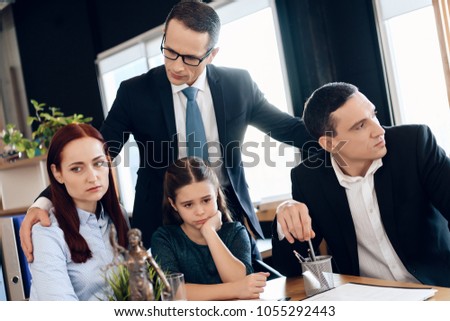 Lawyer calms family down with little girl who gets divorced. Family in office of family lawyer. Young man and beautiful woman decide who will be main guardian of little girl.