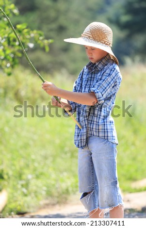 Portrait of teenage fisherman with rod at straw hat