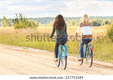 Two girls enjoying nature during bike trip at countryside