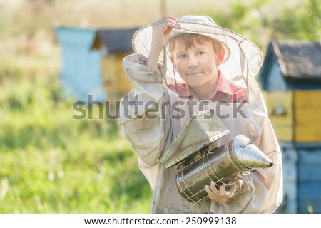 Teenage beekeeper using a smoker on a bee yard
