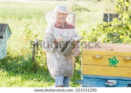 Teenage farm beekeeper checking hives on a bee yard