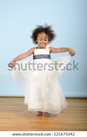 Little girl dances in her white formal dress