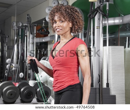 African American woman wearing a red doing arm exercises in the gym