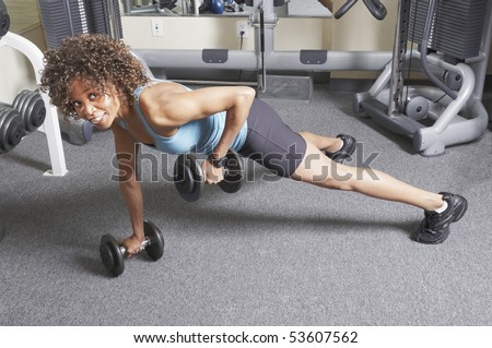 African American woman doing floor exercises with free weights