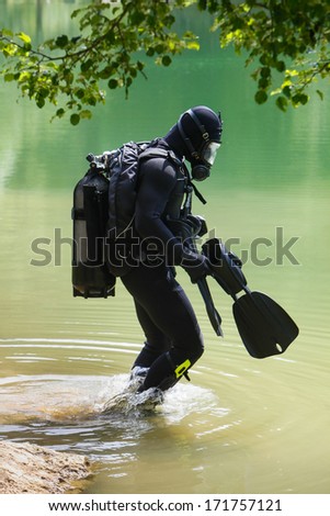 Scuba diver with full face mask entering lake
