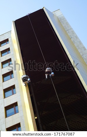 Two men cleaning a facade