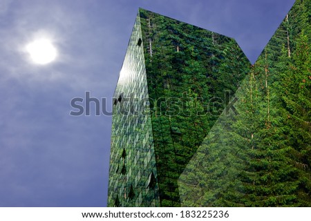Green energy in the city: modern building covered with spruce forest