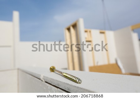 Prefabricated house in the making with screw in foreground
